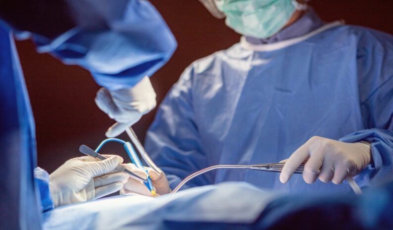 Médicos realizando cirurgia em paciente.