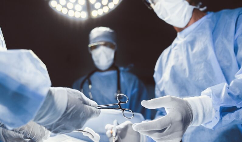 Médicos cirurgiões operando em sala de cirurgia.