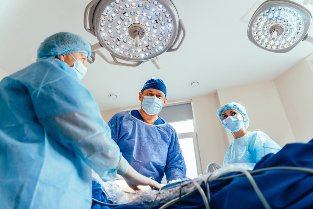 Médicos cirurgiões operando em sala de cirurgia.