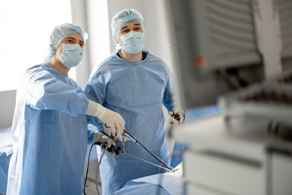 Médicos em sala de cirurgia realizando cirurgia minimamente invasiva